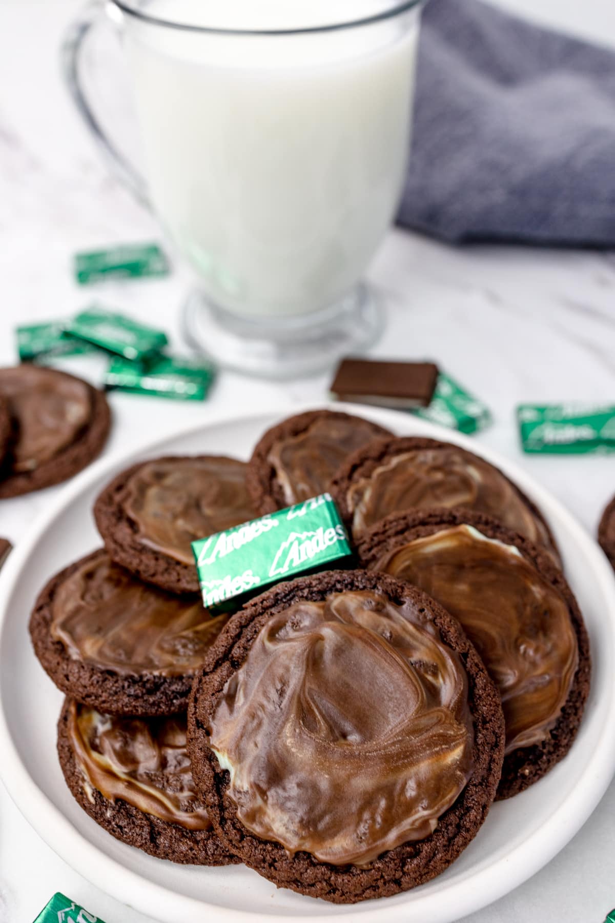 Andes Mint Chocolate cookies on a plate with a glass of milk in the back. 