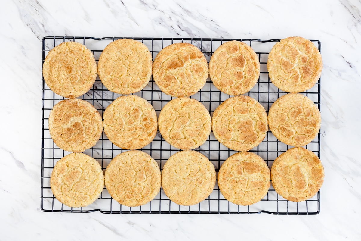 Top view of freshly baked eggnog snickerdoodle cookies cooling on a baking rack.