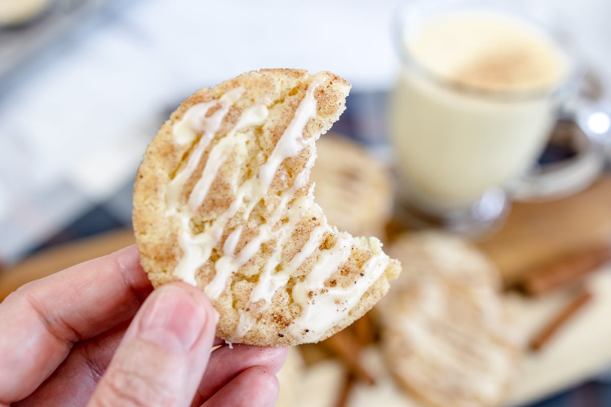 Close up of an Eggnog Snickerdoodle Cookie being held up with a bite taken out of it.