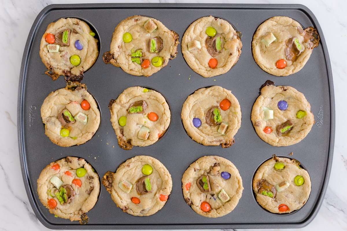 Top view of freshly baked candy cookies in a muffin baking tray. 