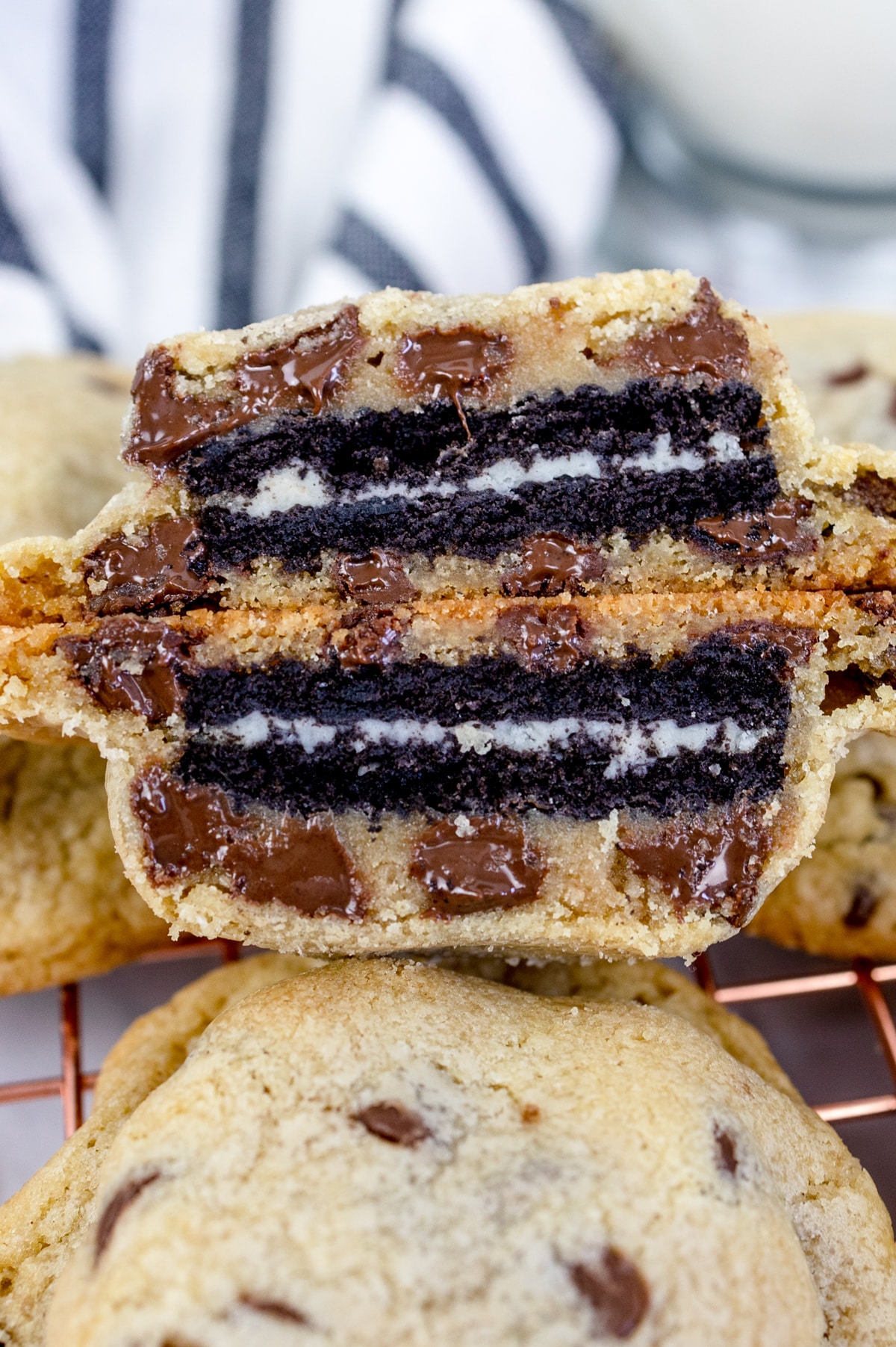 Close up of an Oreo stuffed chocolate chip cookie, cut in half so you can see inside it. 