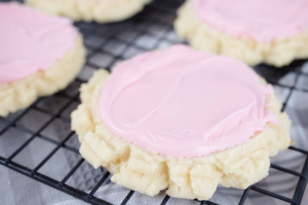 Close up of swig cookies with pink frosting on them.