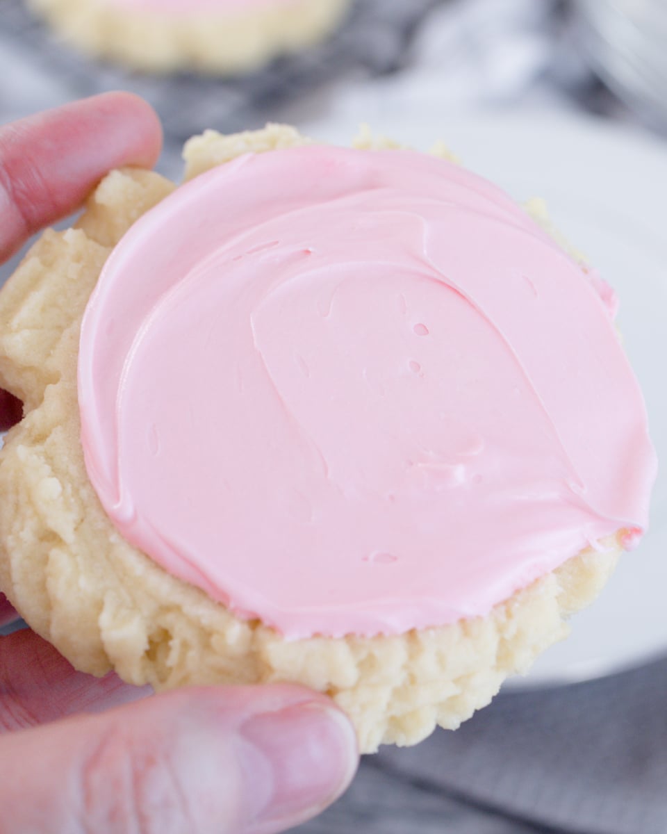 Close up top view of a copycat swig sugar cookie with pink frosting on top.