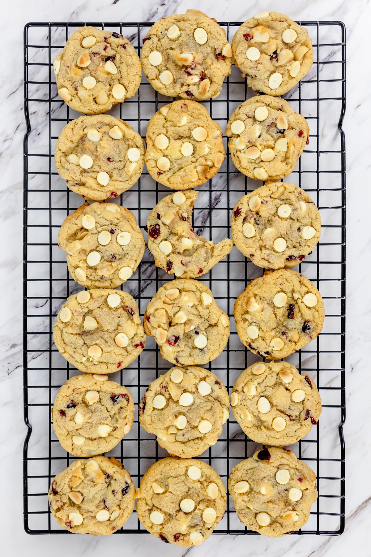 Top view of wire rack filled with white chocolate cranberry macadamia nut cookies.