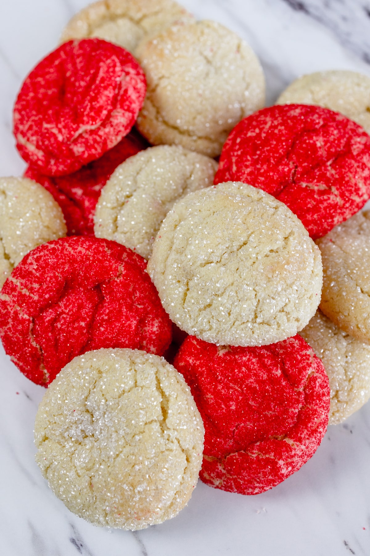 Close up of a pile of red and plain colored sugar cookies.