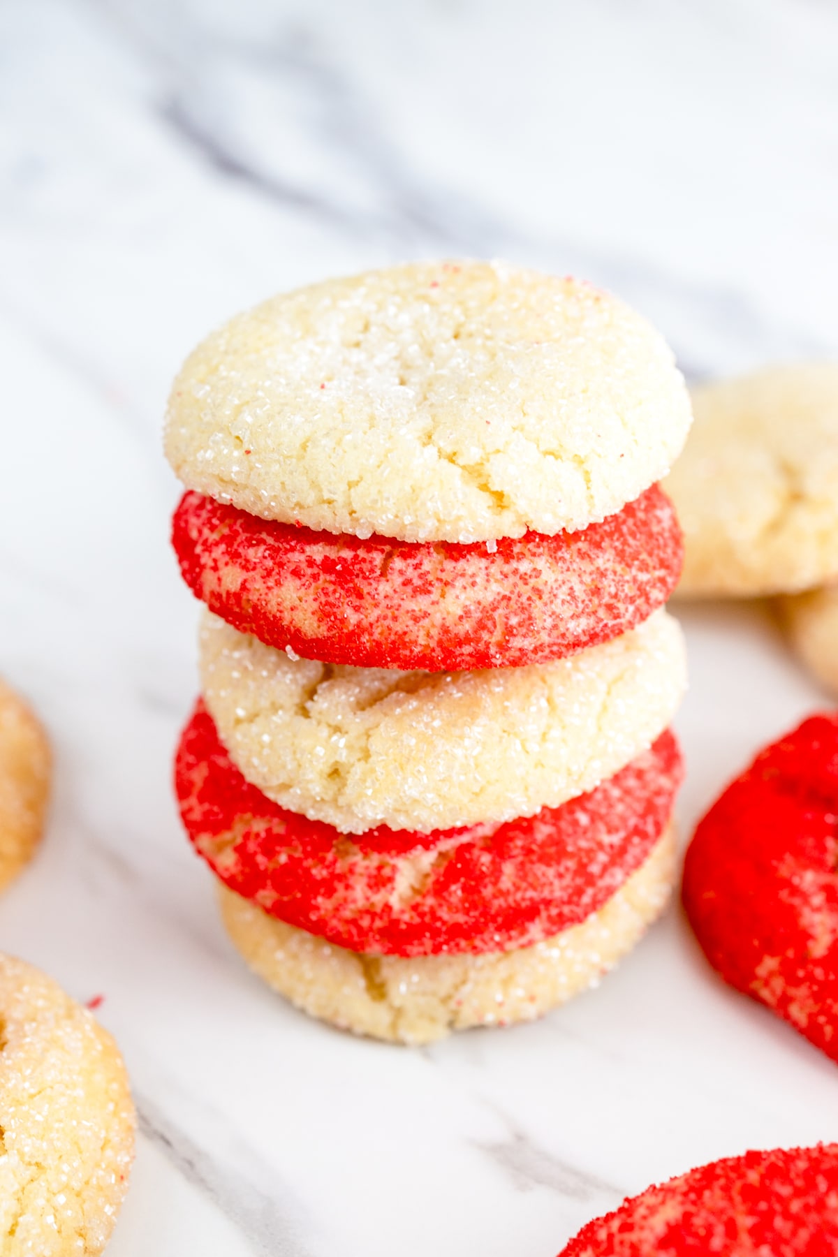 Close up of a pile of uncolored and red sugar cookies.