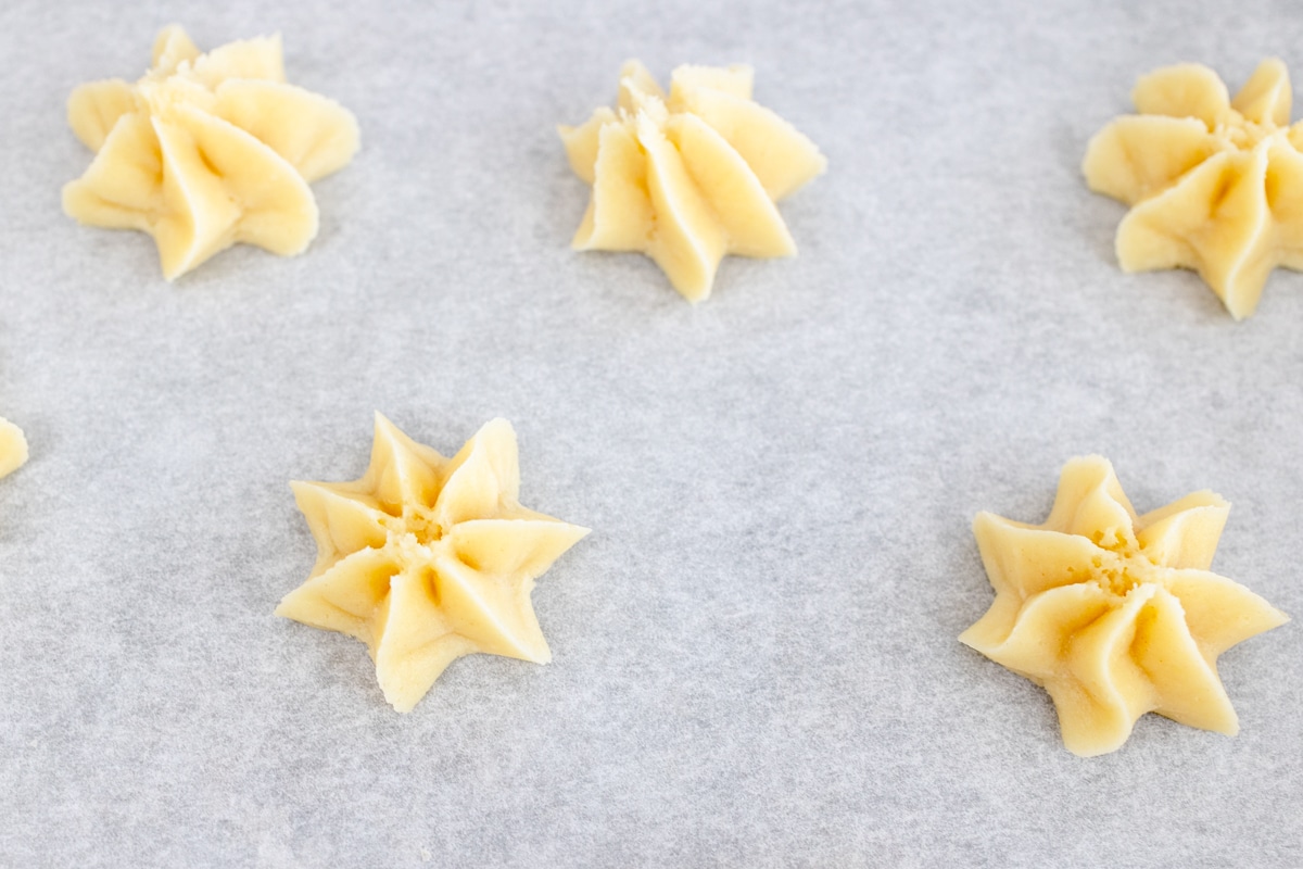 Close up of small stars of butter cookie dough. 