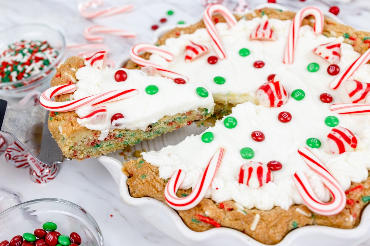 Close up of festive cookie pie with a slice being taken out of it.