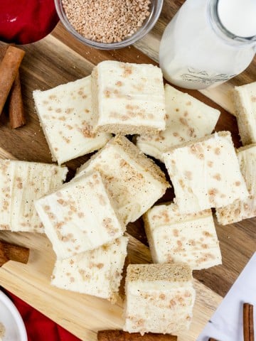Top view of Eggnog Bars stacked on top of each other on a chopping board.