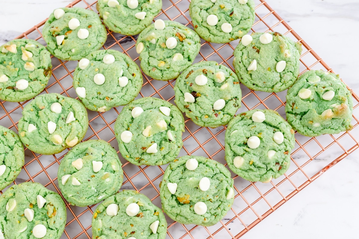 Top view of pistachio cookies freshly baked lined up on a wire rack.