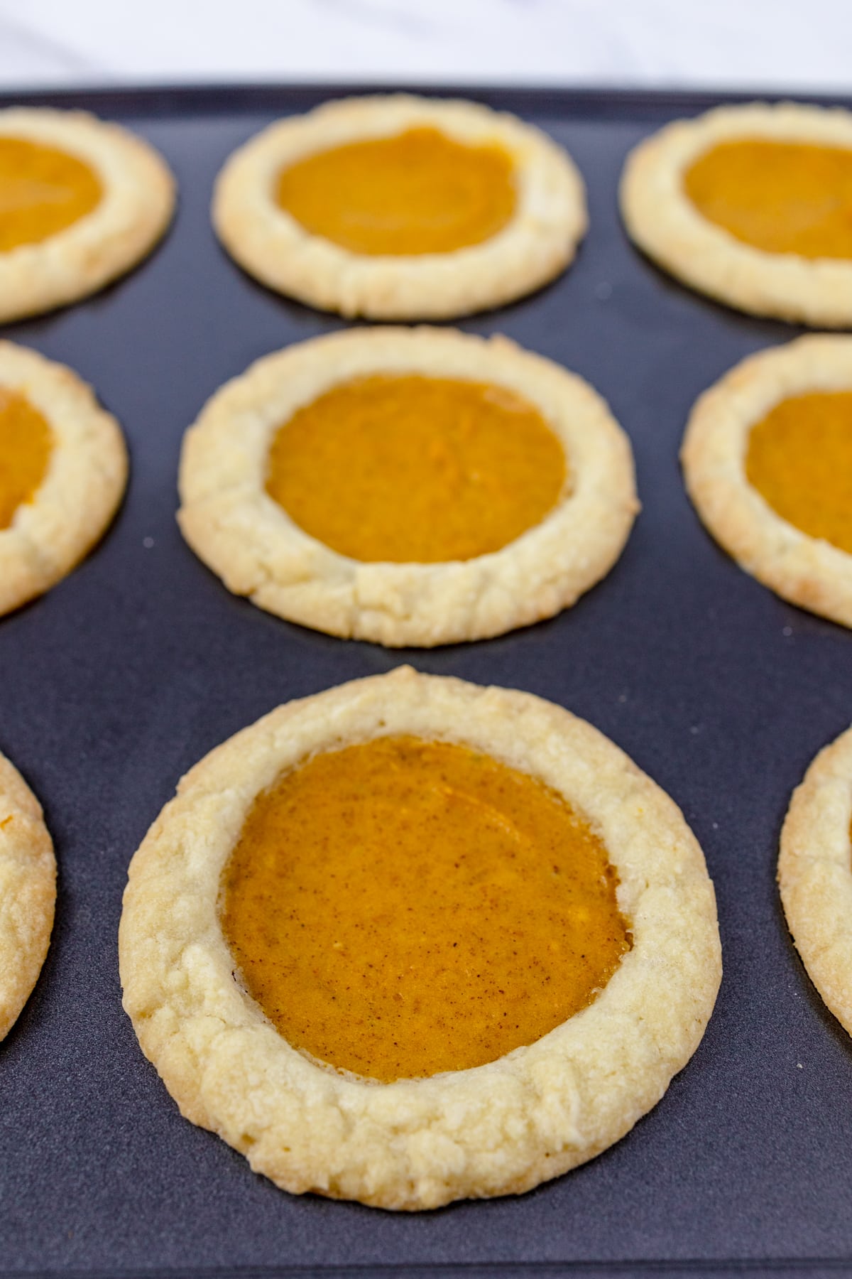 Close up of pumpkin pie cookies on a baking tray.