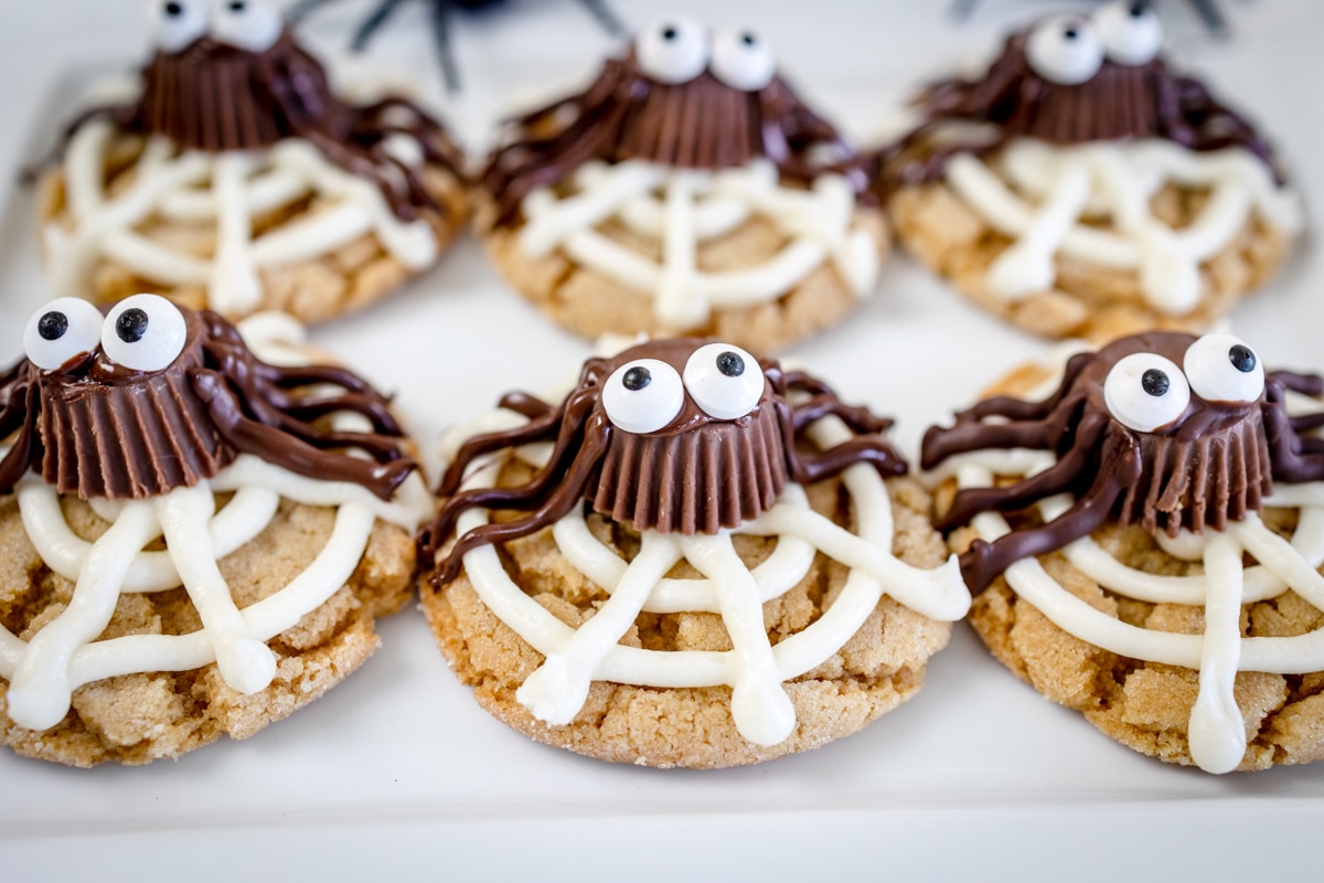Close up of peanut butter spider cookies on a white surface.