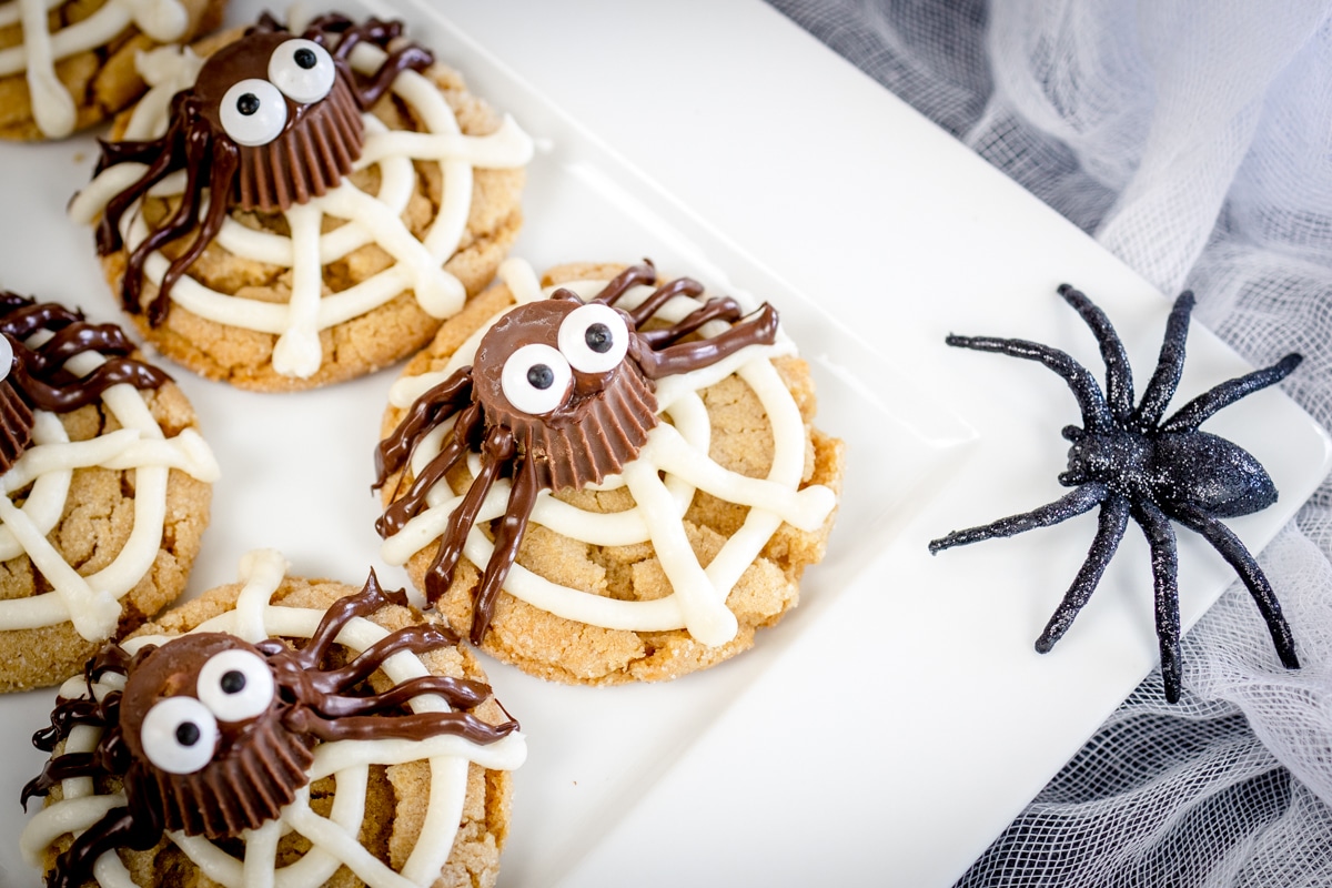 Close up of peanut butter spider cookies on a white surface.