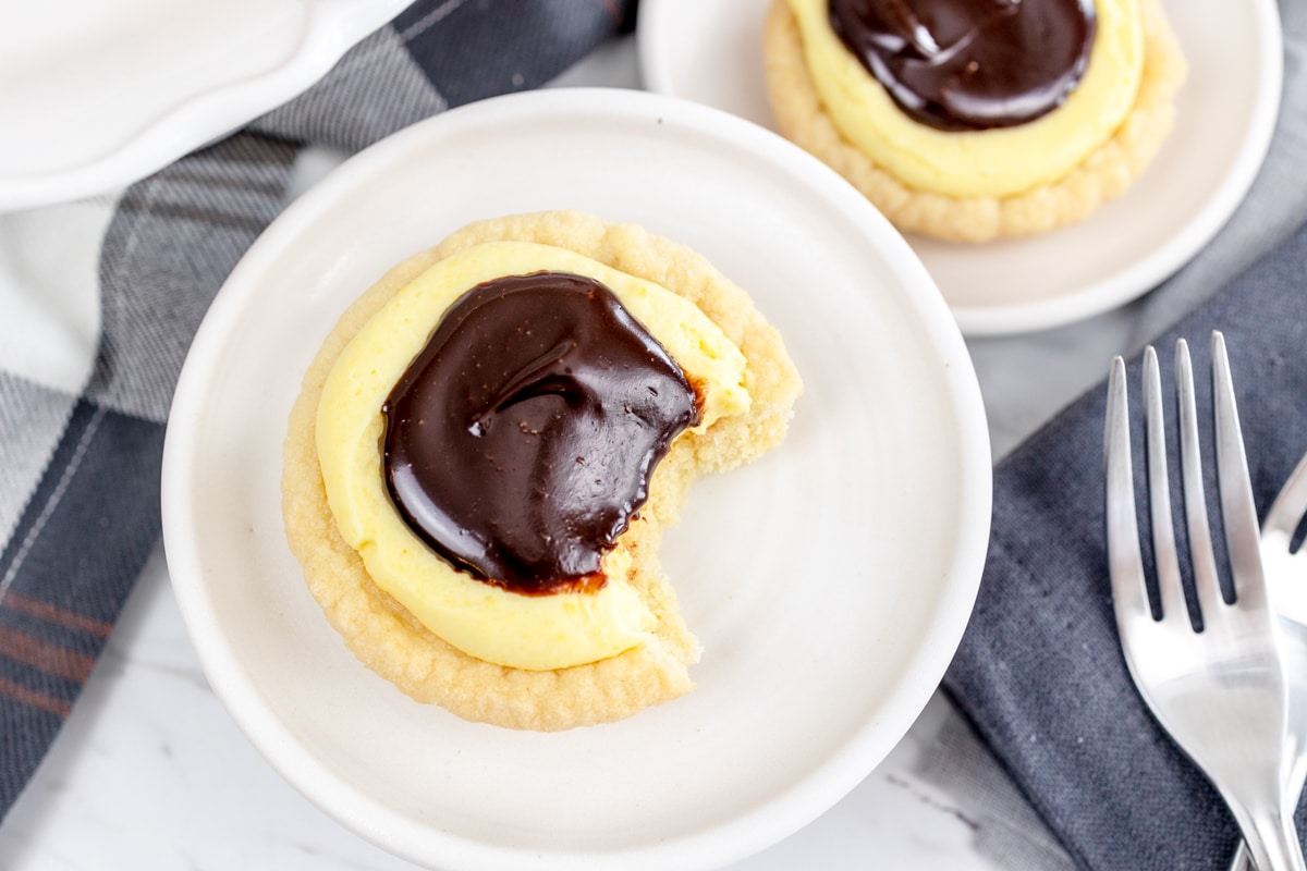 Top view of a Boston cream cookie on a white plate. 