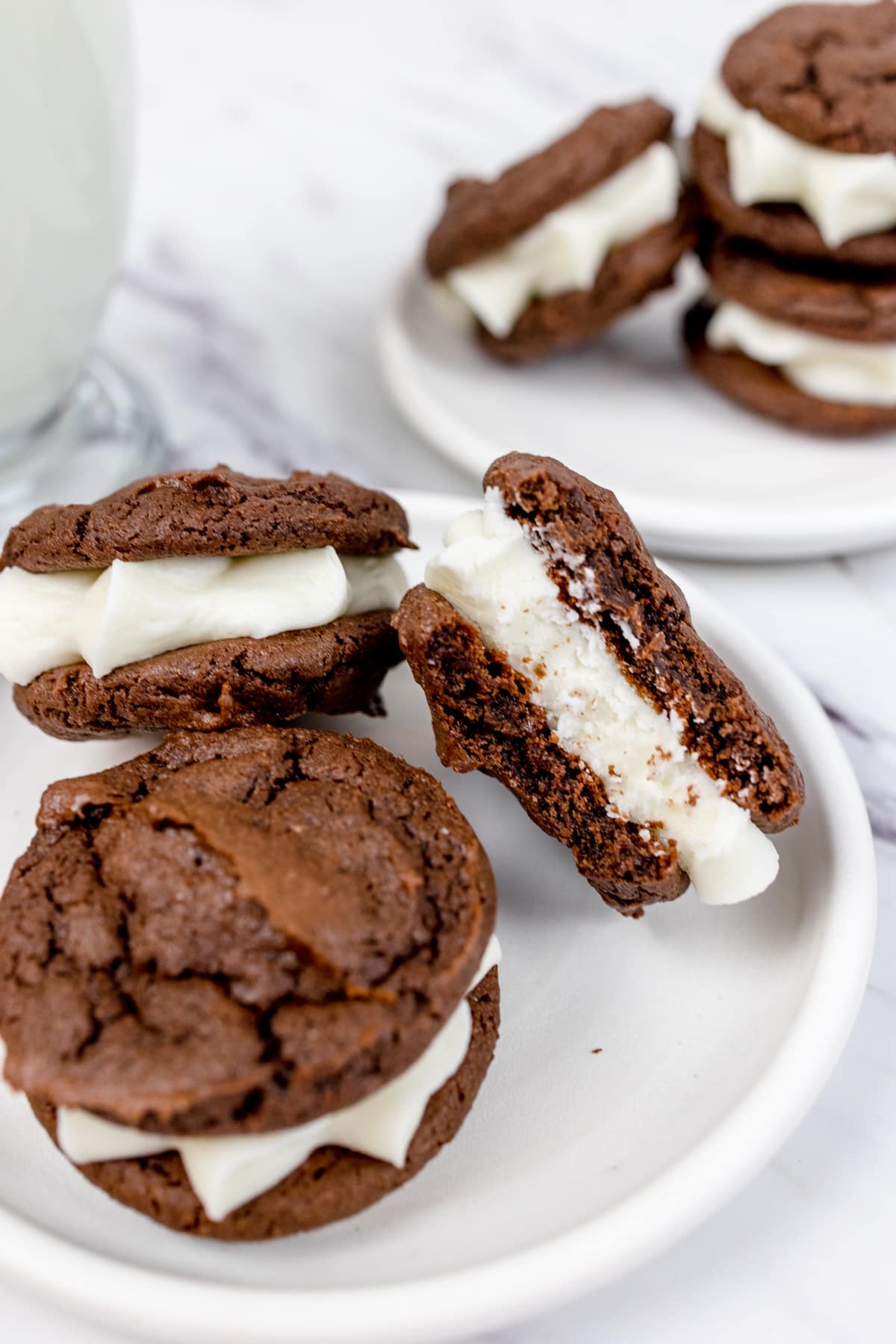 Two white plates with piles of Oreo Cakester Cookies piled on them.