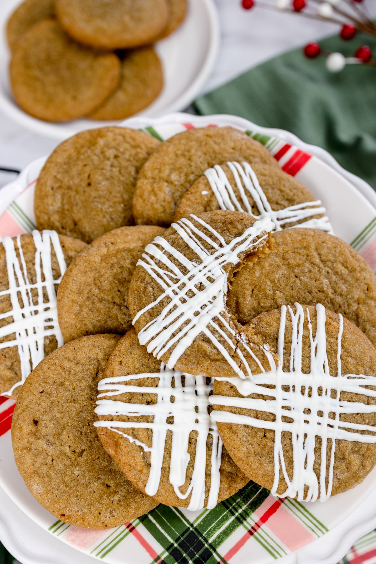 A plate filled with Molasses cookies, some decorated with a drizzle of icing.