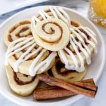 Close up of Cinnamon Roll Cookies on a plate with cinnamon sticks on the plate too.