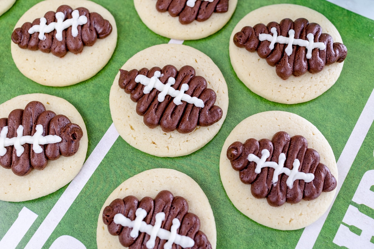 Top view of football sugar cookies on top of a touchdown mat. 