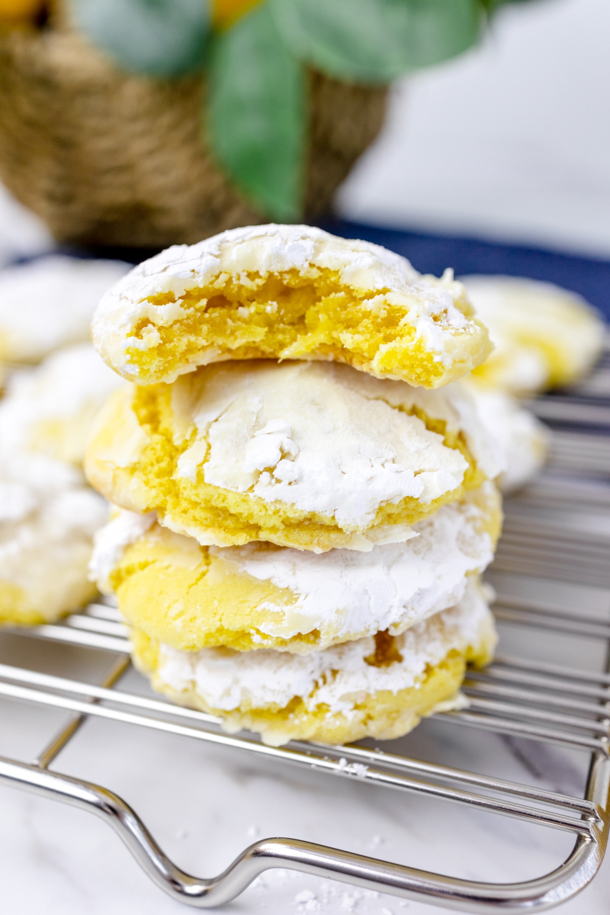 Close up of a stack of Lemon Crinkle Cookies on a wire rack. 