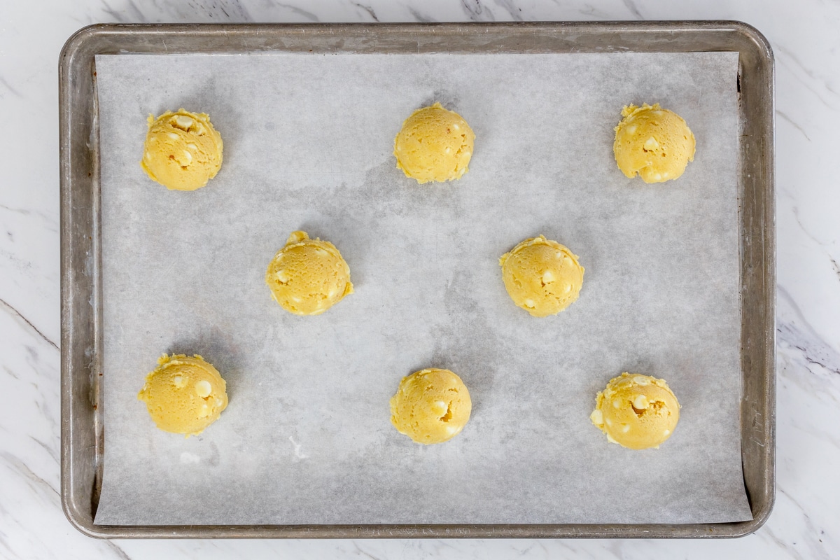 Top view of baking tray lined with lemon cookie dough balls. 