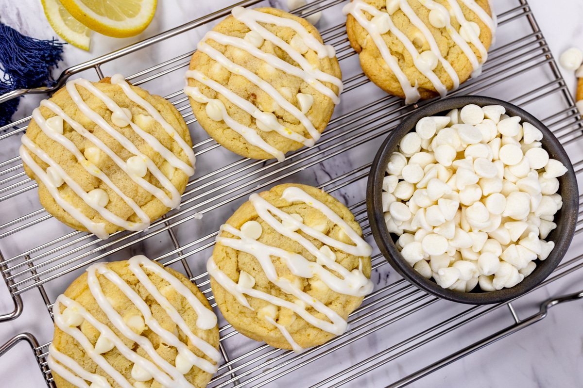 Top view of lemon white chocolate chip cookies with drizzle on a cooling rack. 