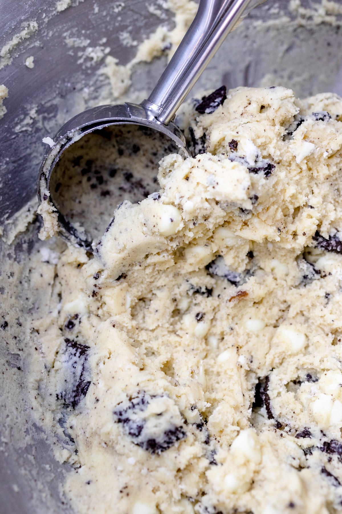 Close up of a cookie scoop scooping out Oreo cheesecake cookie dough.