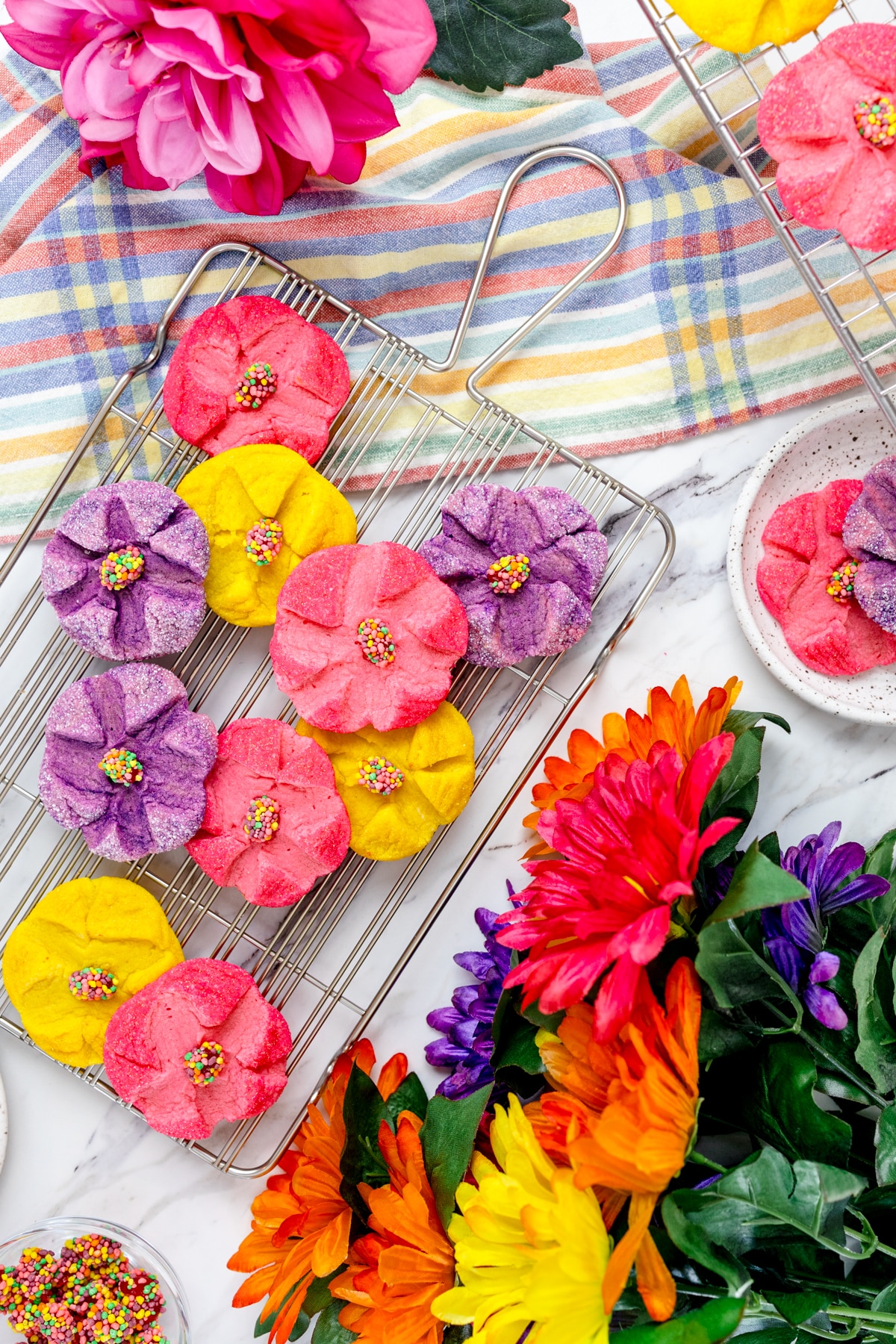Top view of colorful spring flower sugar cookies on a wire rack. 
