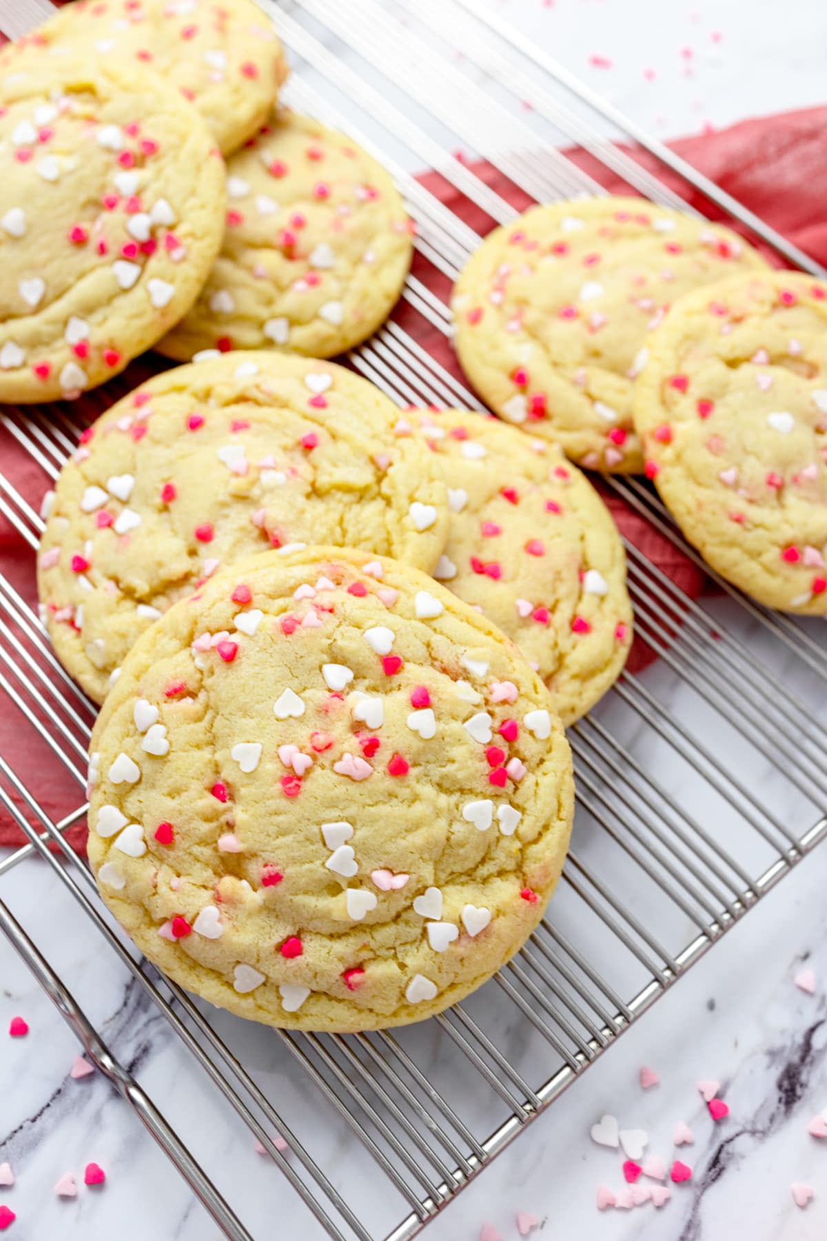 Close-up of a pile of Sprinkle Sugar Cookies on a wire rack. 