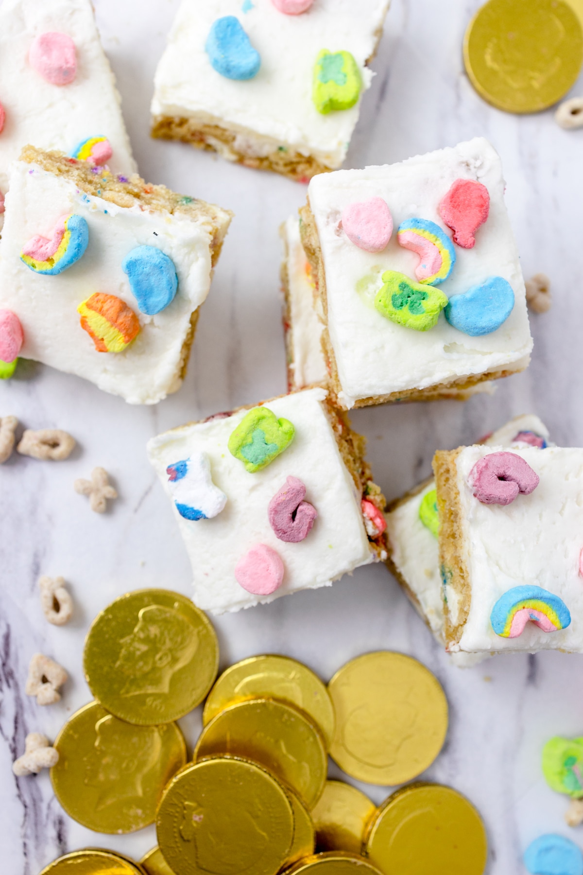Top view of Lucky Charms bar squares on a worktop with gold chocolate coins around them. 
