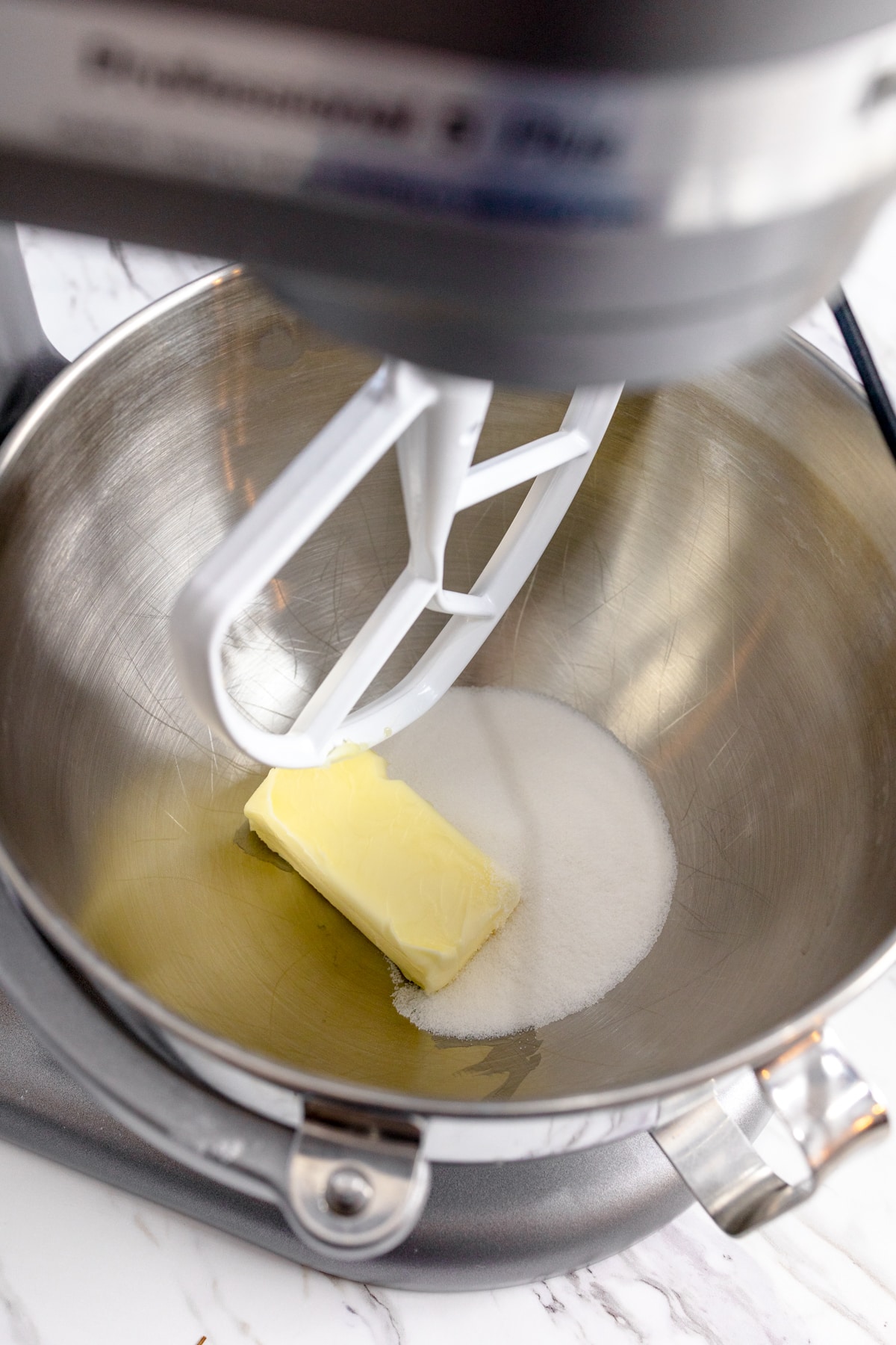 Close up of sugar and butter being mixed in a stand mixer.