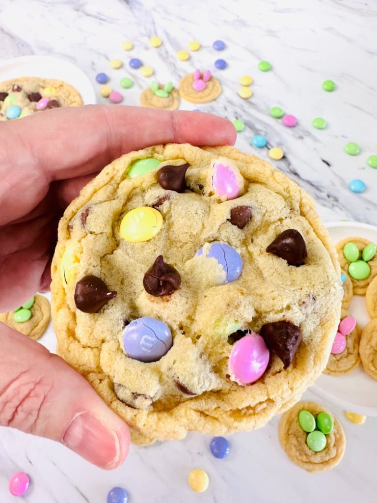 Top view close-up of an Easter M&M Cookie being held in mid-air.
