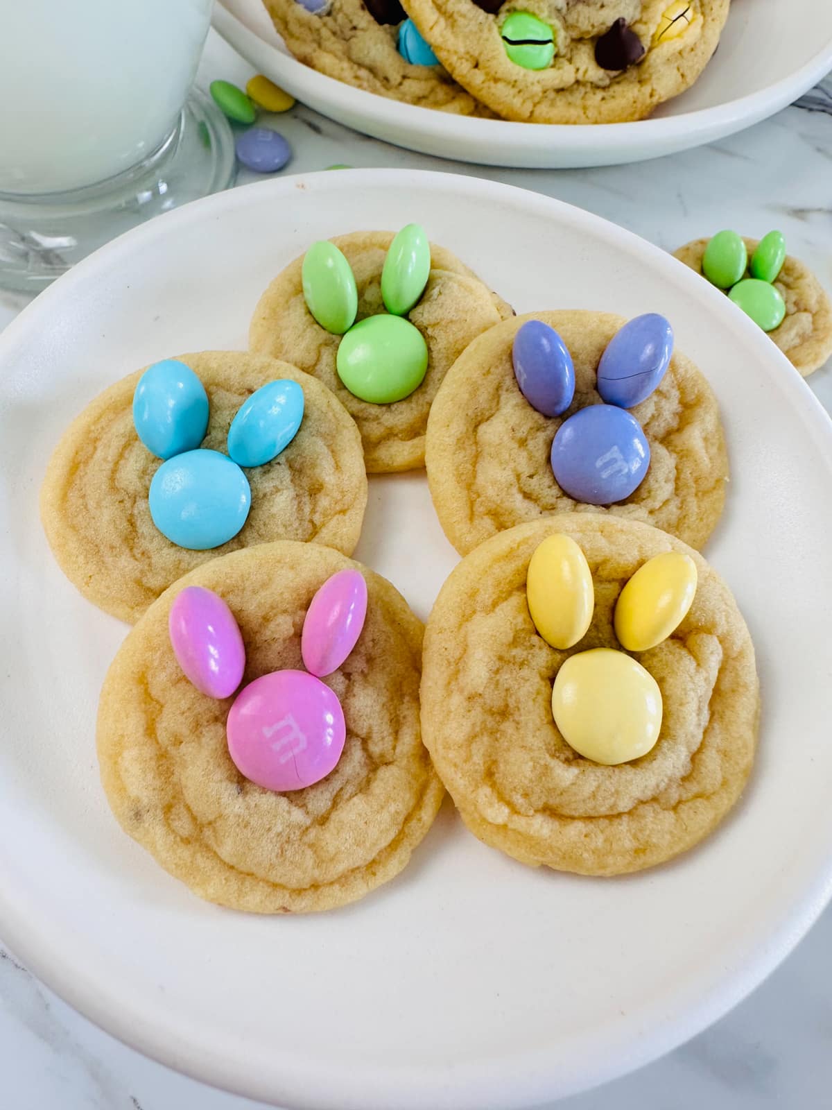Top view of a cookie filled with small cookies with pastel M&Ms on top in the shape of a bunny head for Easter. 