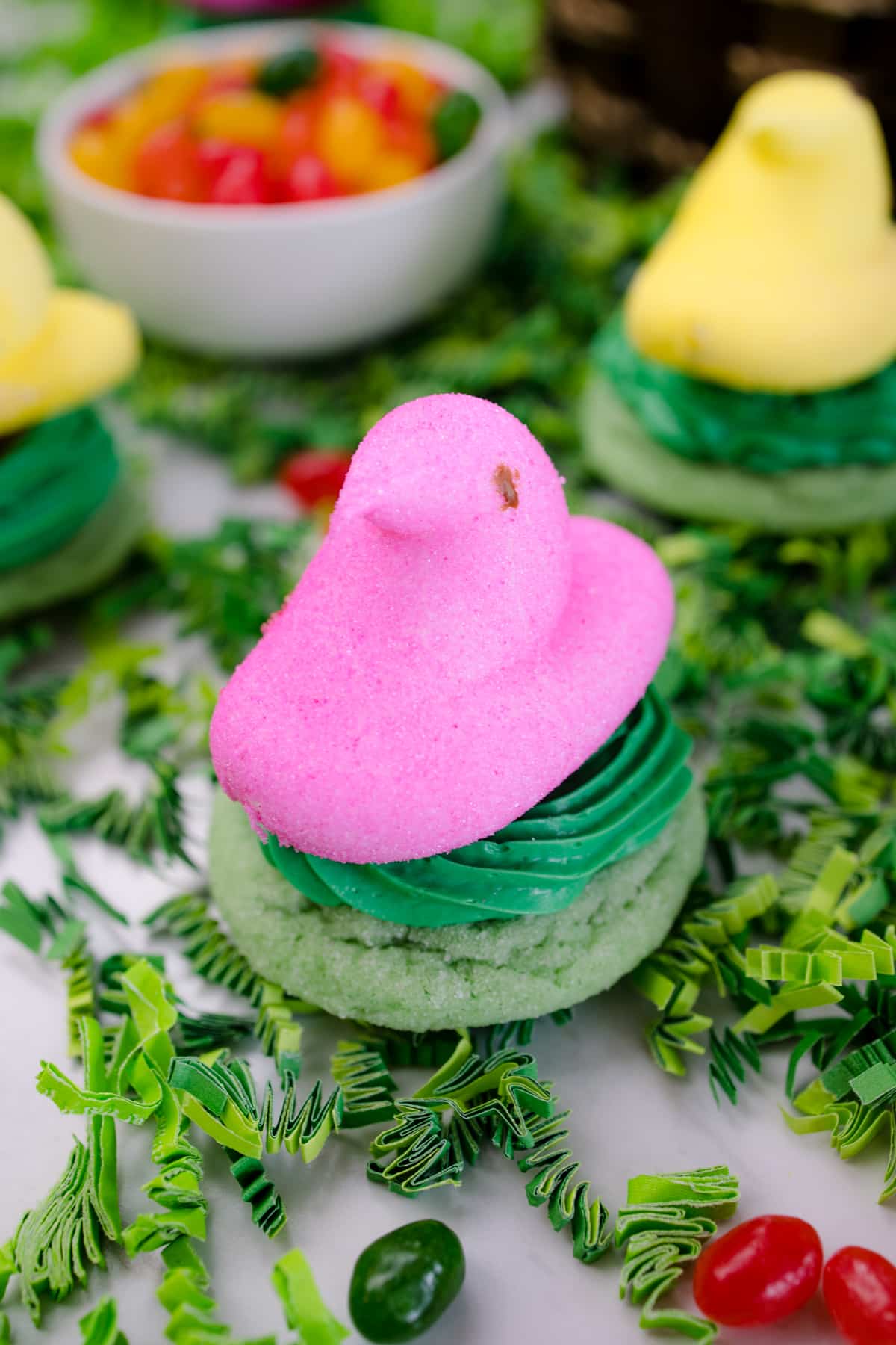Hero image of a Peep Nest Cookie, with a green base and a pink candy bird sitting on top of it.