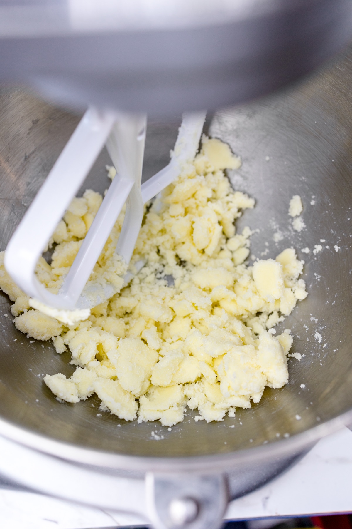 Close up of a mixing bowl with butter and sugar mixed together.