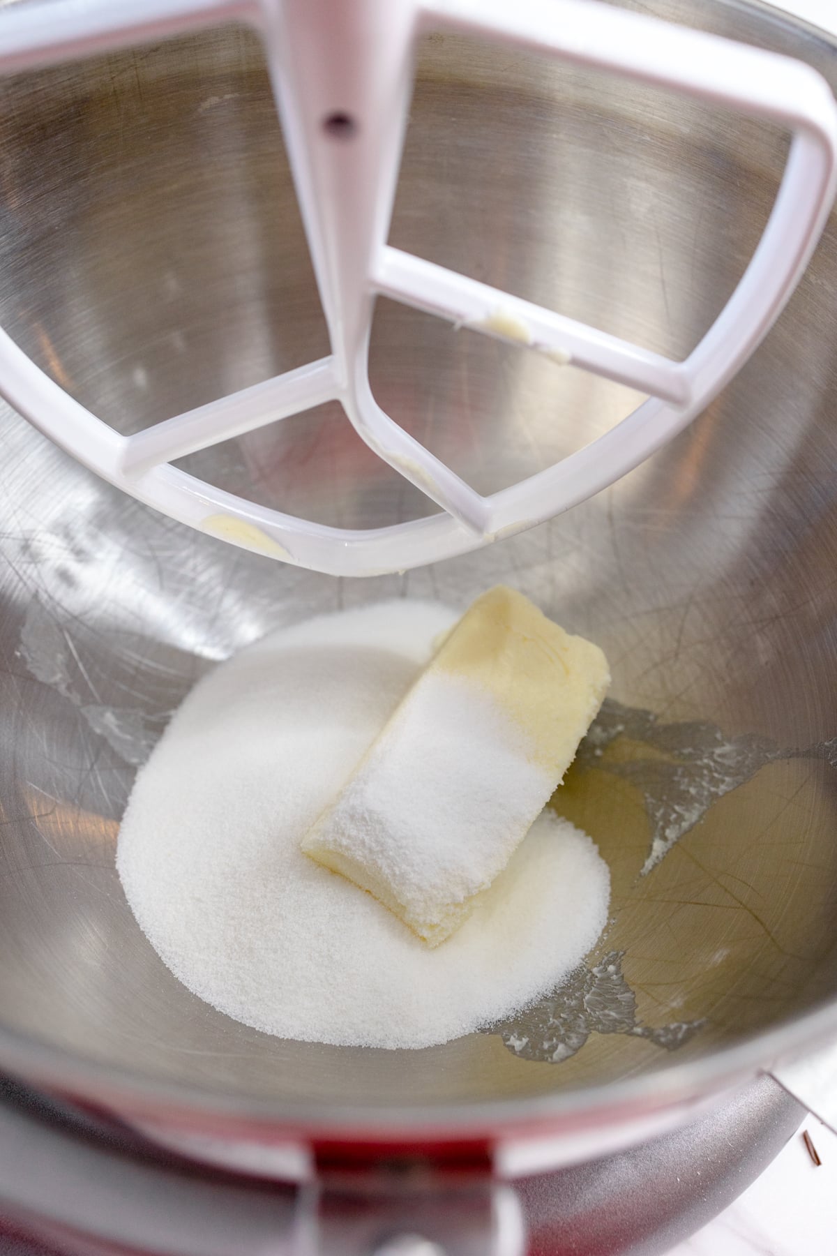 Close up of butter and sugar in a bowl of a stand mixer.