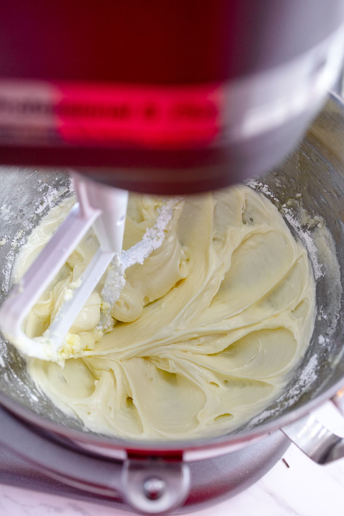 Close up of butter and sugar being creamed in the bowl of a stand mixer. 