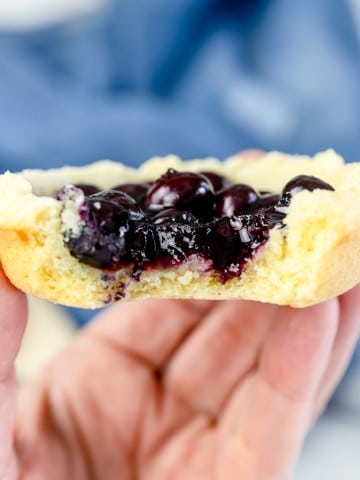 Close up of a Blueberry Pie Cookie with a bite taken out of it.