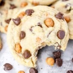 Close up of Caramel Chocolate Chip Cookies in a pile with a bite taken out of the one at the front.