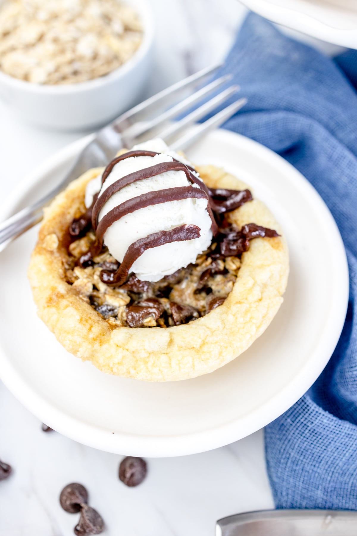 Top view of a chocolate chip cookie pie on a white plate. 