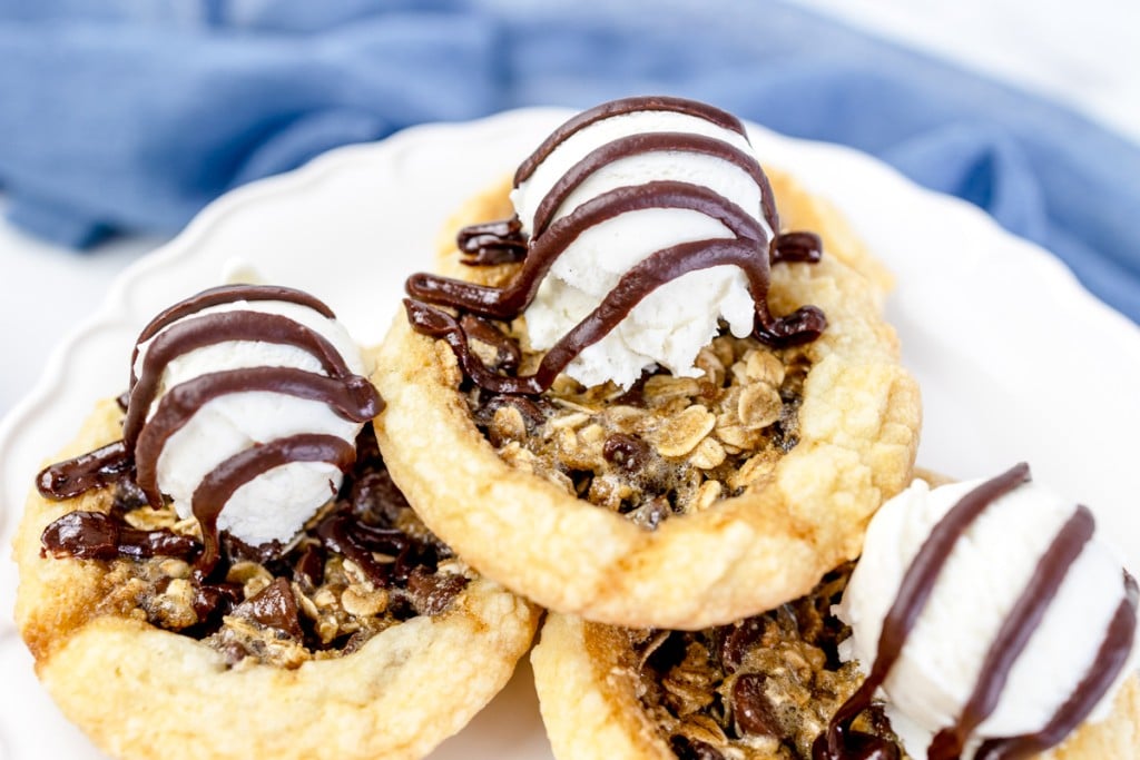 Close up of chocolate chip pie cookies in a pile on a white plate. 