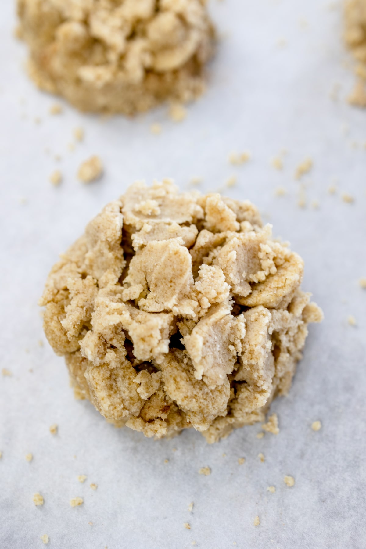 Close up of a coffee cake cookie dough ball on parchment paper.