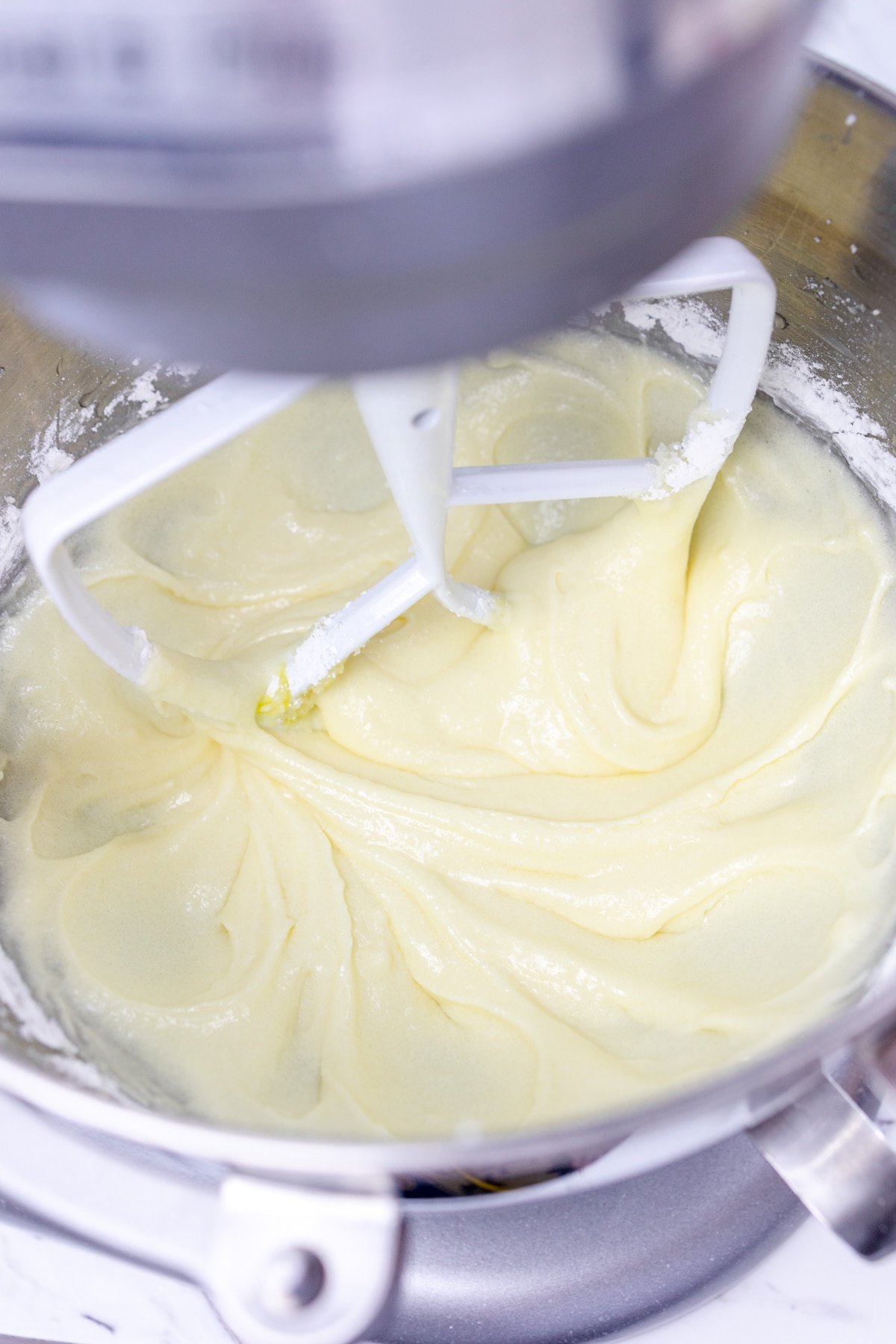 Close up of a stand mixer bowl with creamed butter and sugar in it.