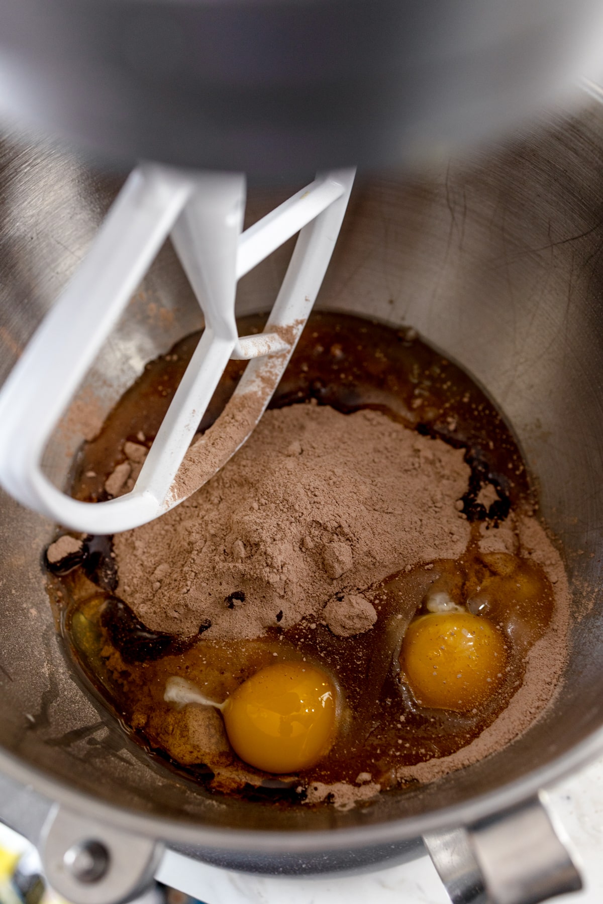 Close up of a standing mixer with unmixed ingredients needed to make a Texas sheet cake cookie. 