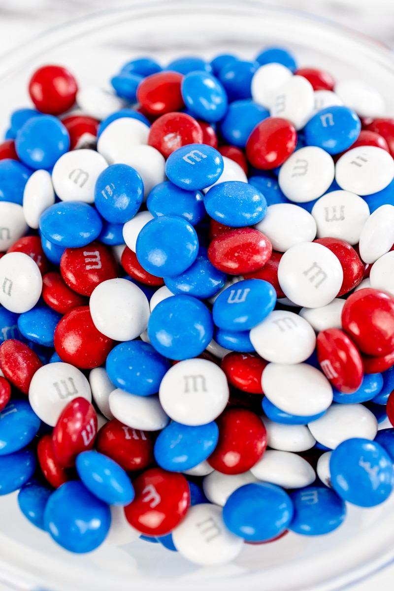 Close up of red, white, and blue M&Ms in a glass bowl.