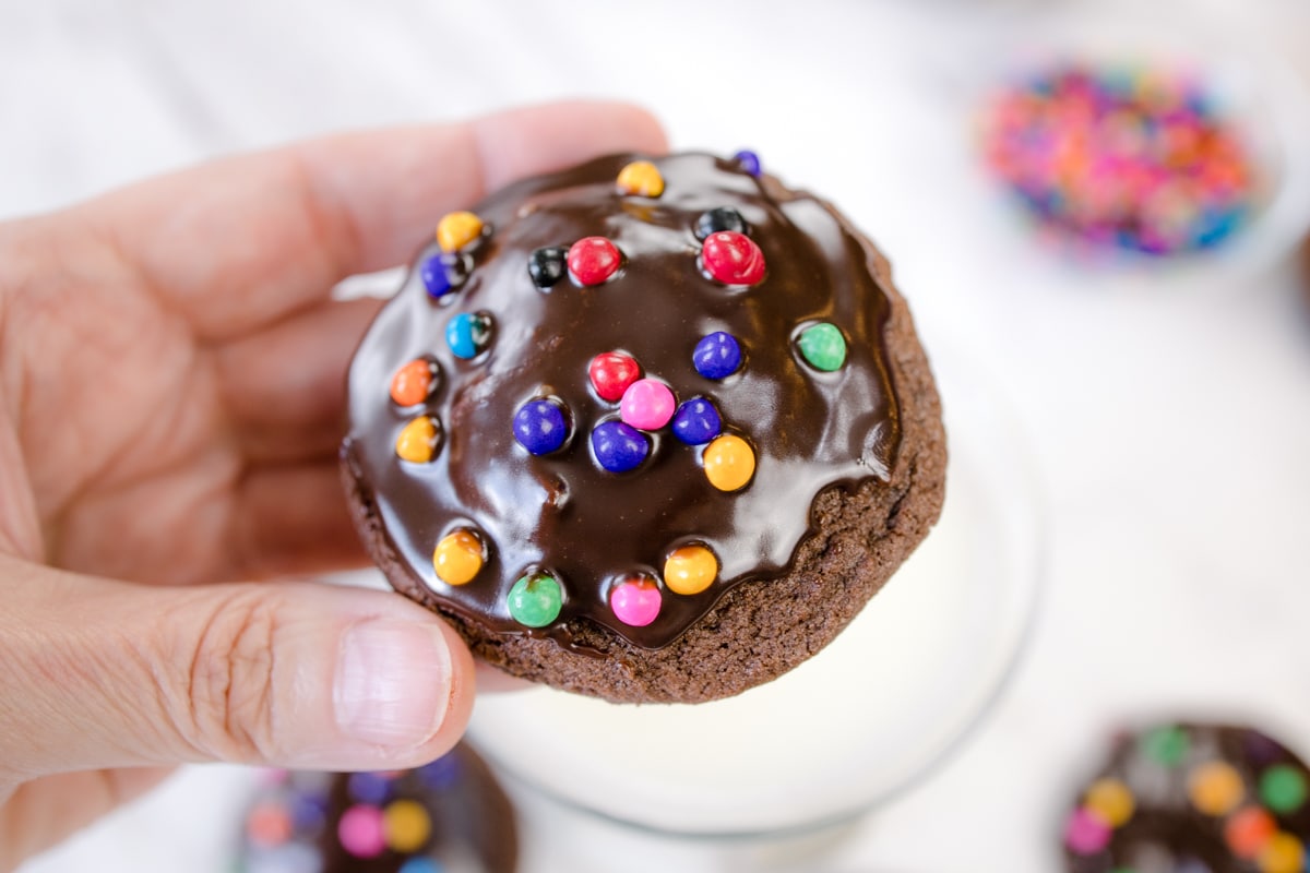 Top view of a cosmic brownie cookie being held in midair by a hand.