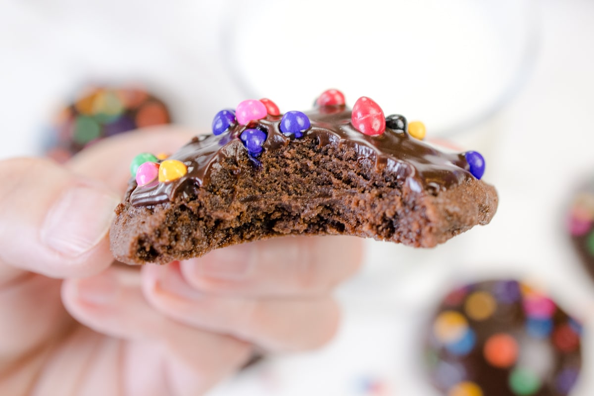 Close up of a cosmic brownie being held in mod air with a bite taken out of it. 