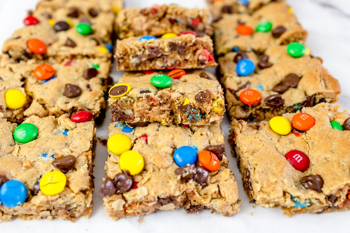 Close up of monster cookie bars freshly cut on a chopping board.