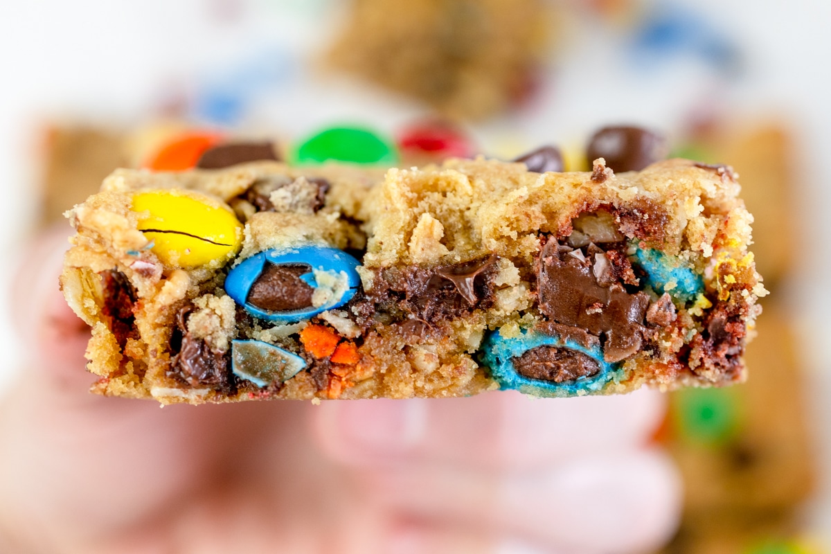 Close up of a monster cookie bar with bites taken out of it. 