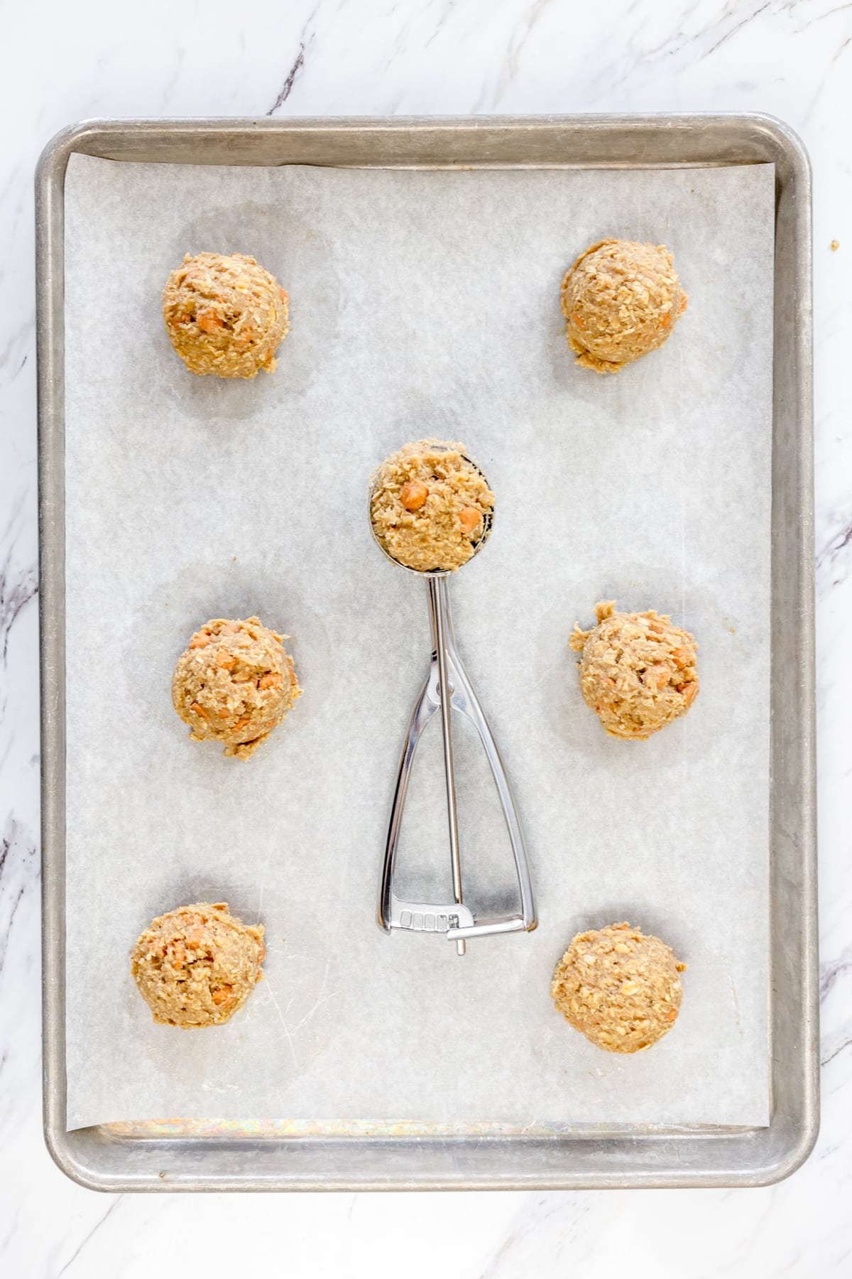Top view of Oatmeal Butterscotch Cookie dough balls on a baking tray lined with parchment paper.