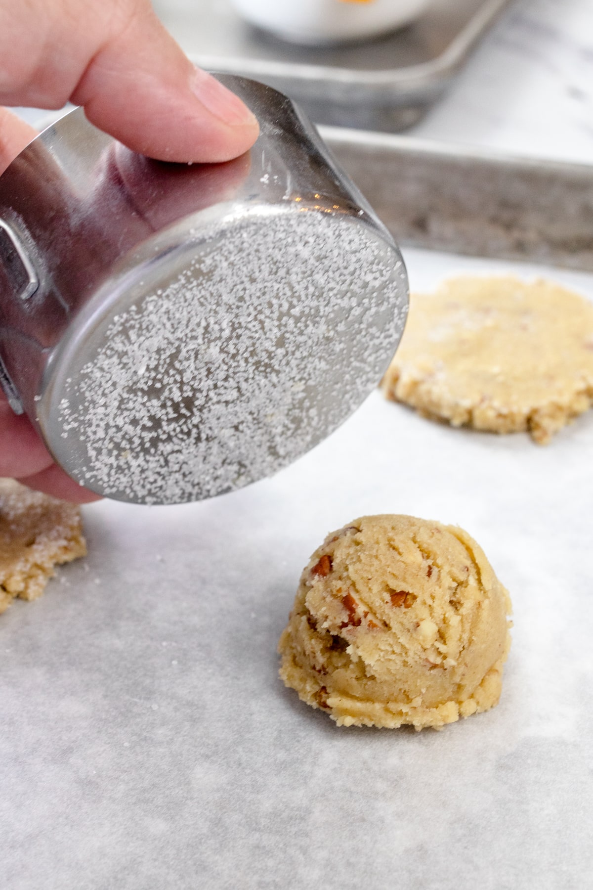 Close up of pecan sandies cookie dough balls being flattened